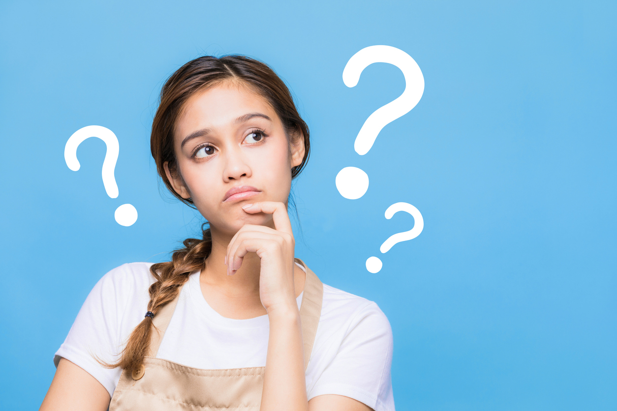 Pensive student, surrounded by large question marks